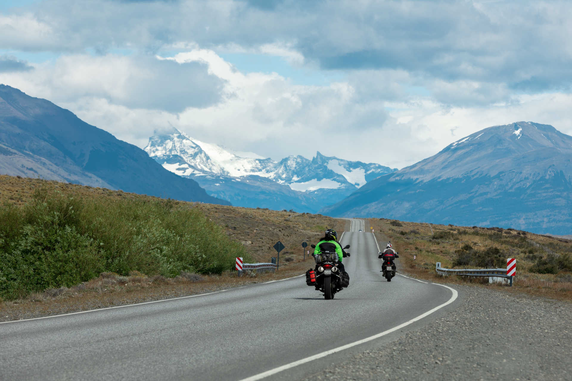 persone in motocicletta sulla strada contro le montagne
